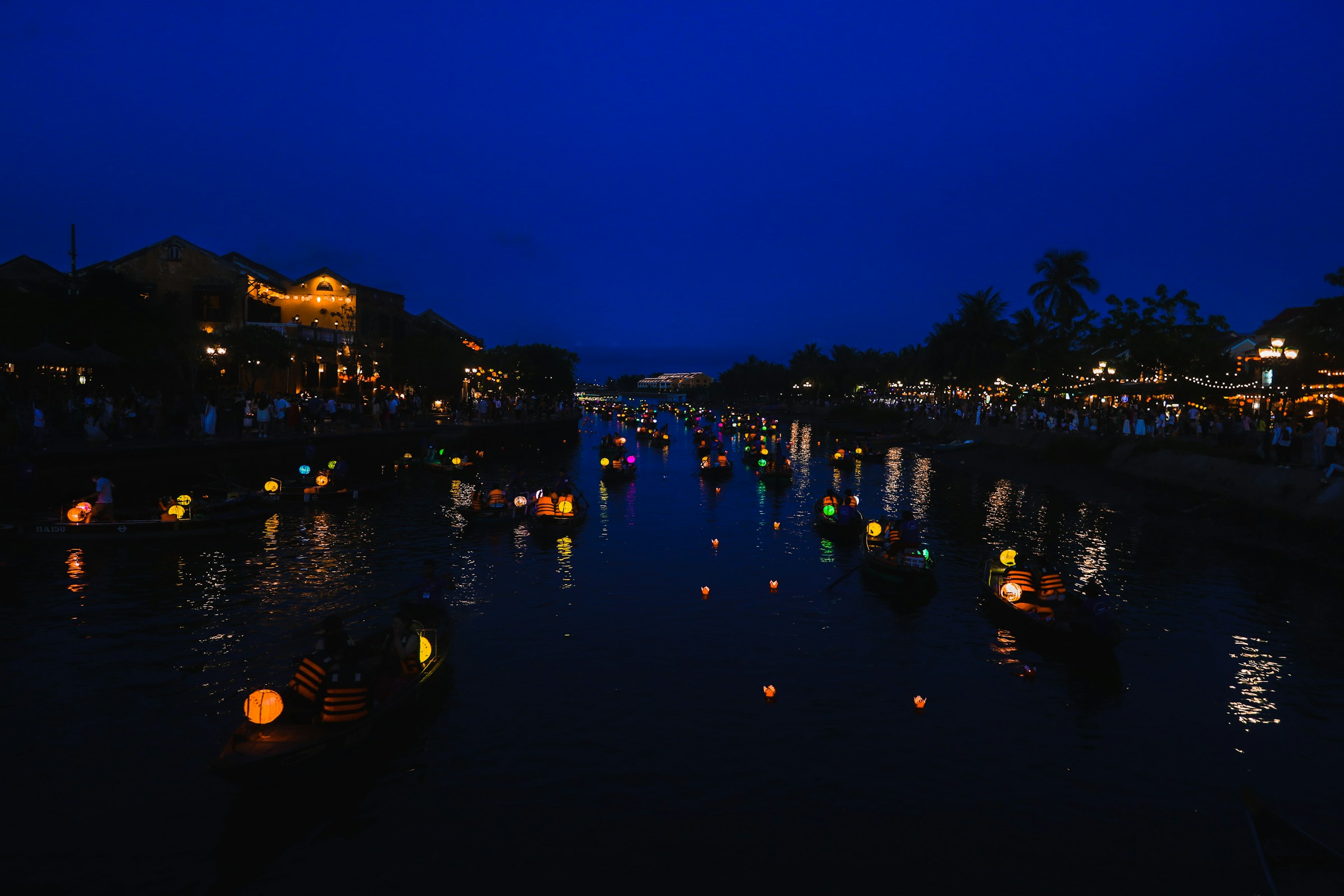 Lanterns floating on a dark river at night, Hoi An