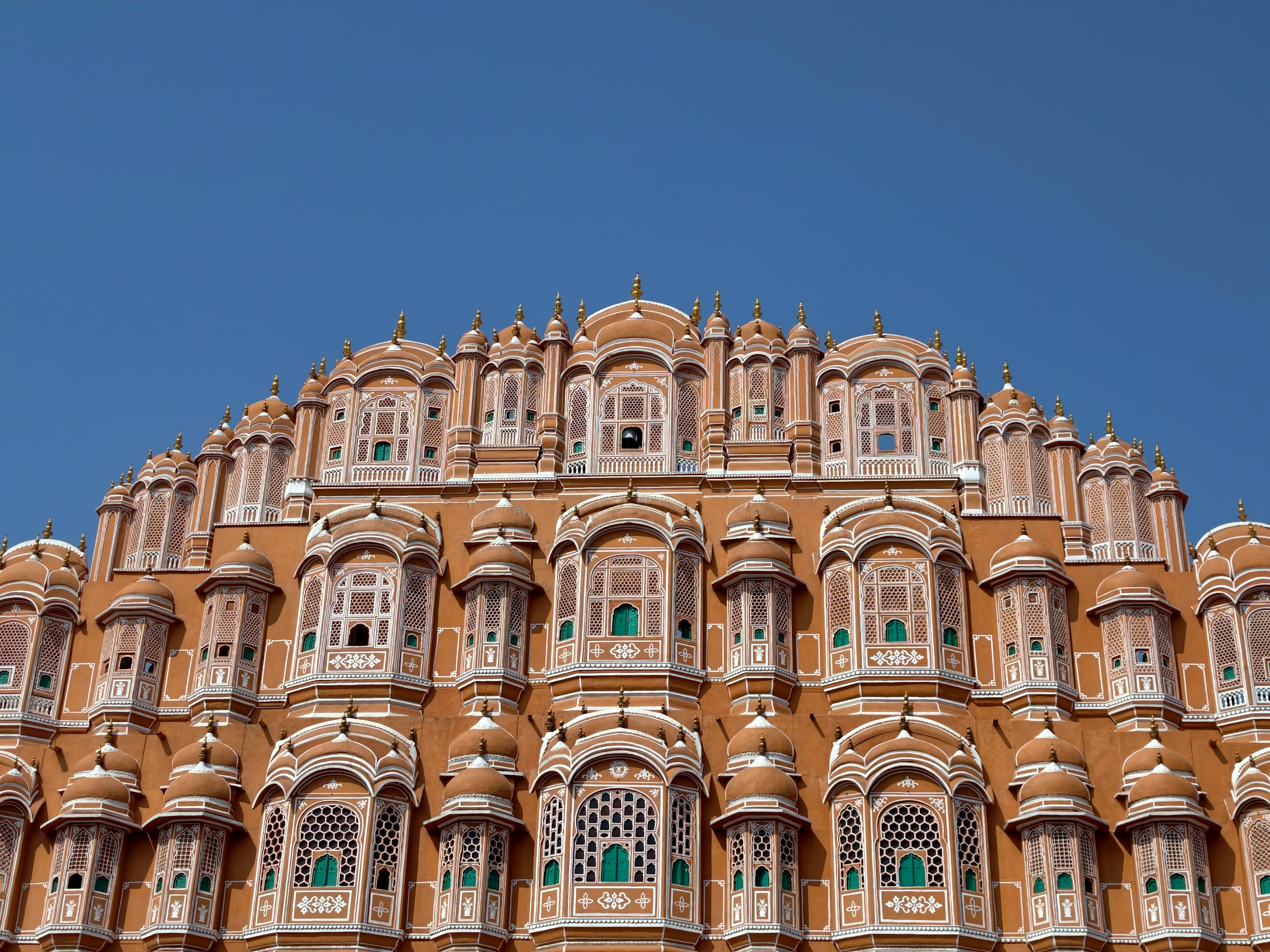 Ornate pink Hawa Mahal palace against a clear blue sky