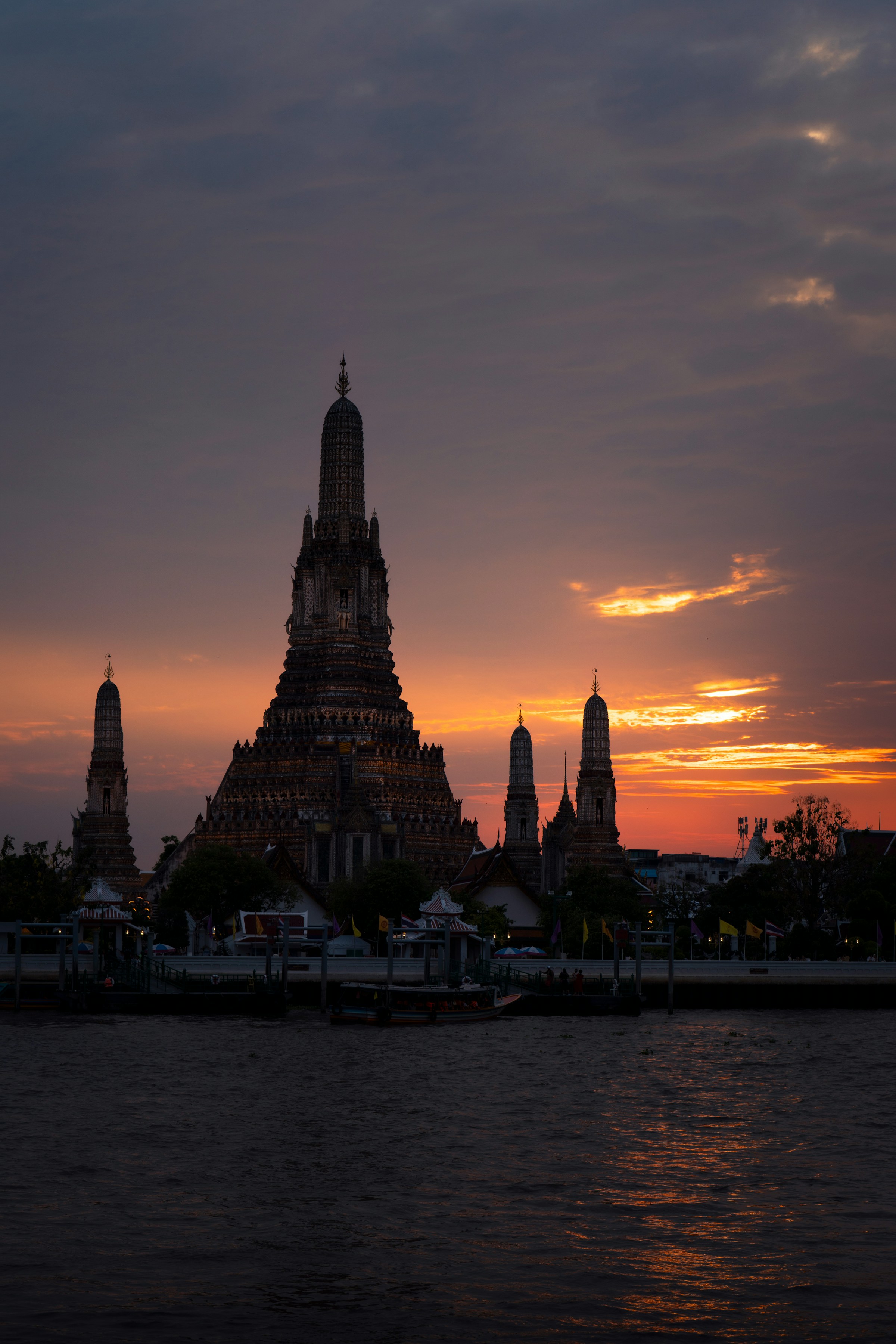 Wat Arun silhouetted at sunset over the river