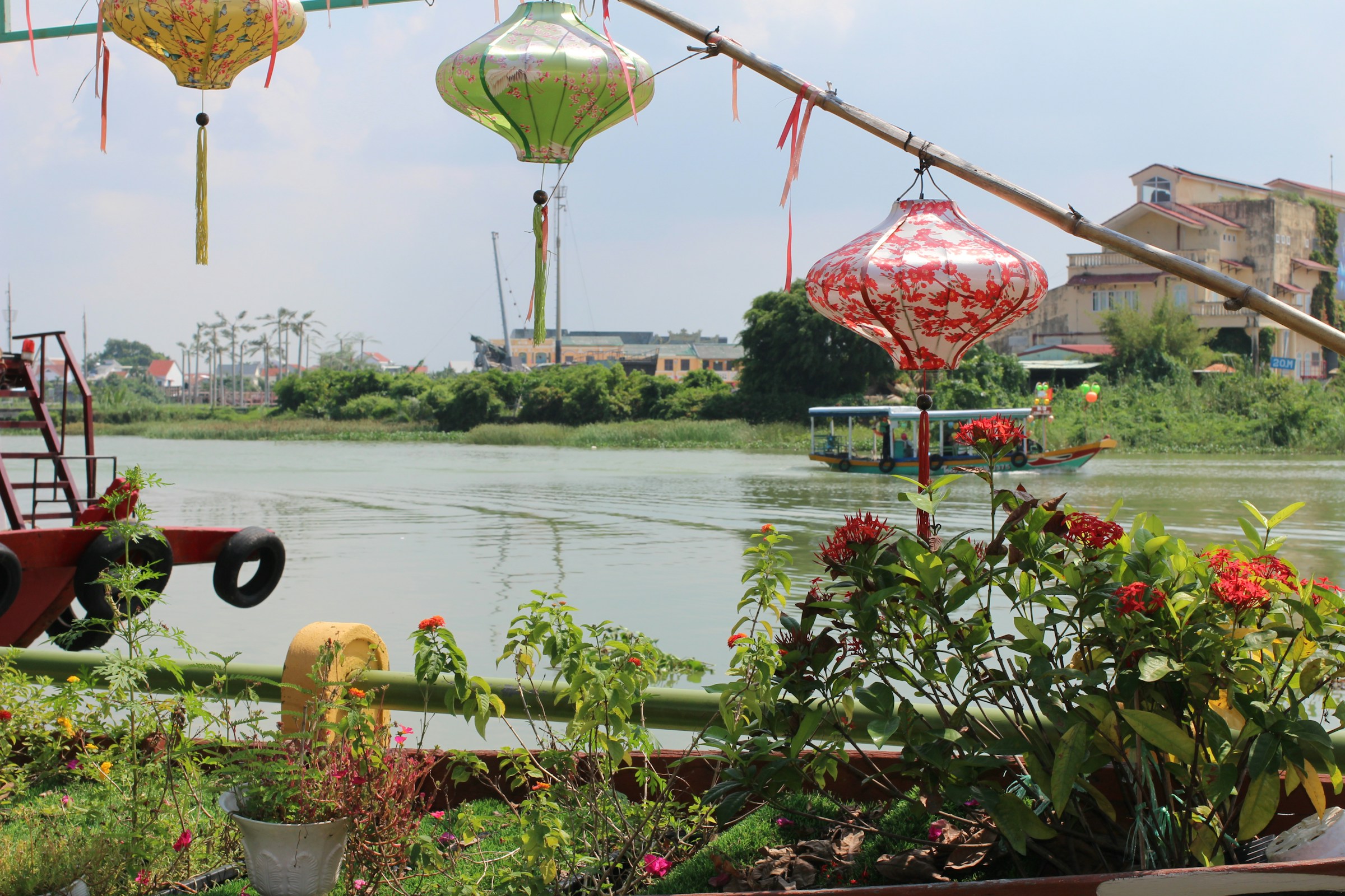 Colourful lanterns hanging from a line over the water, Hoi An