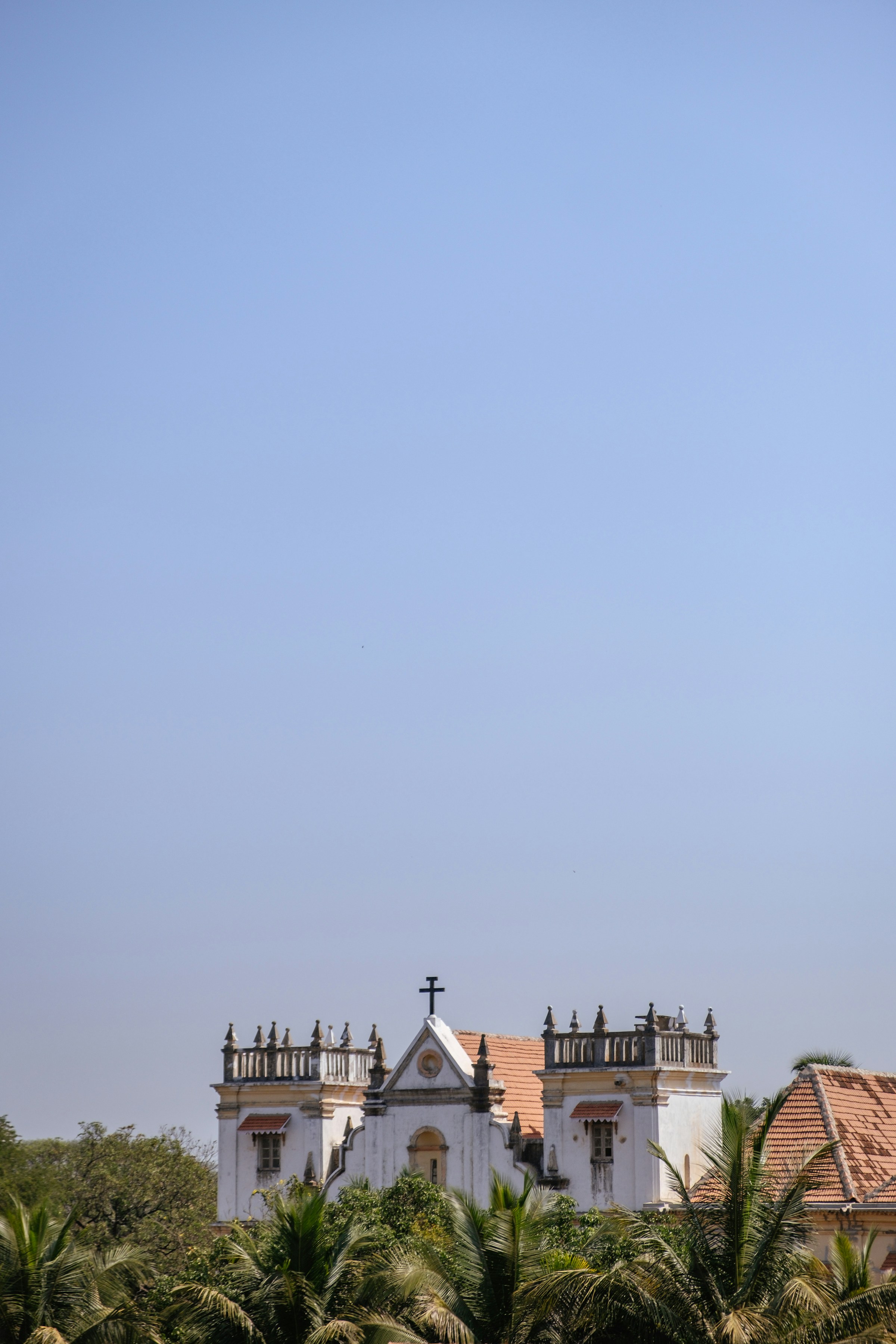 Large white church with a cross on top, Old Goa