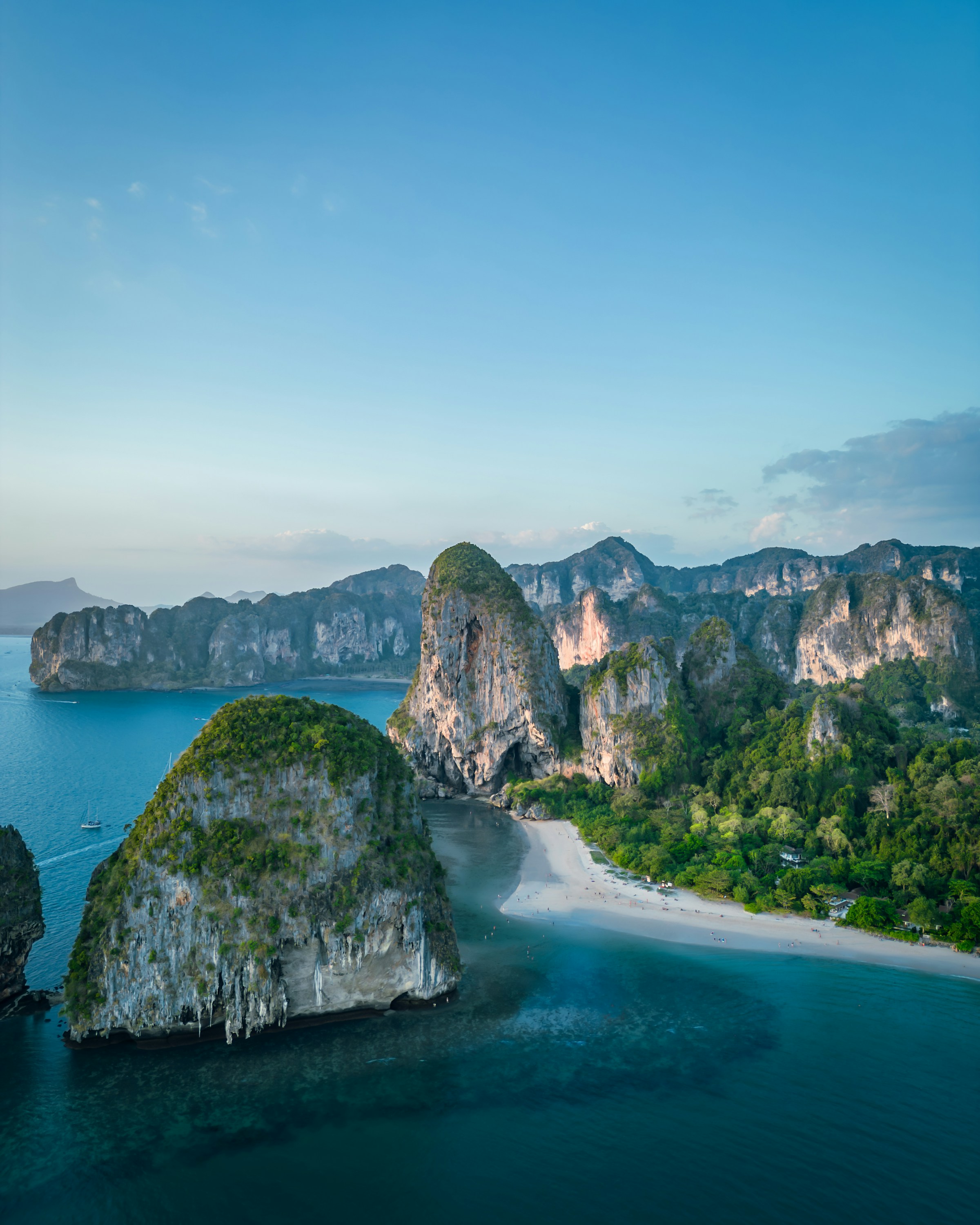 Limestone karsts rising from the ocean near a beach