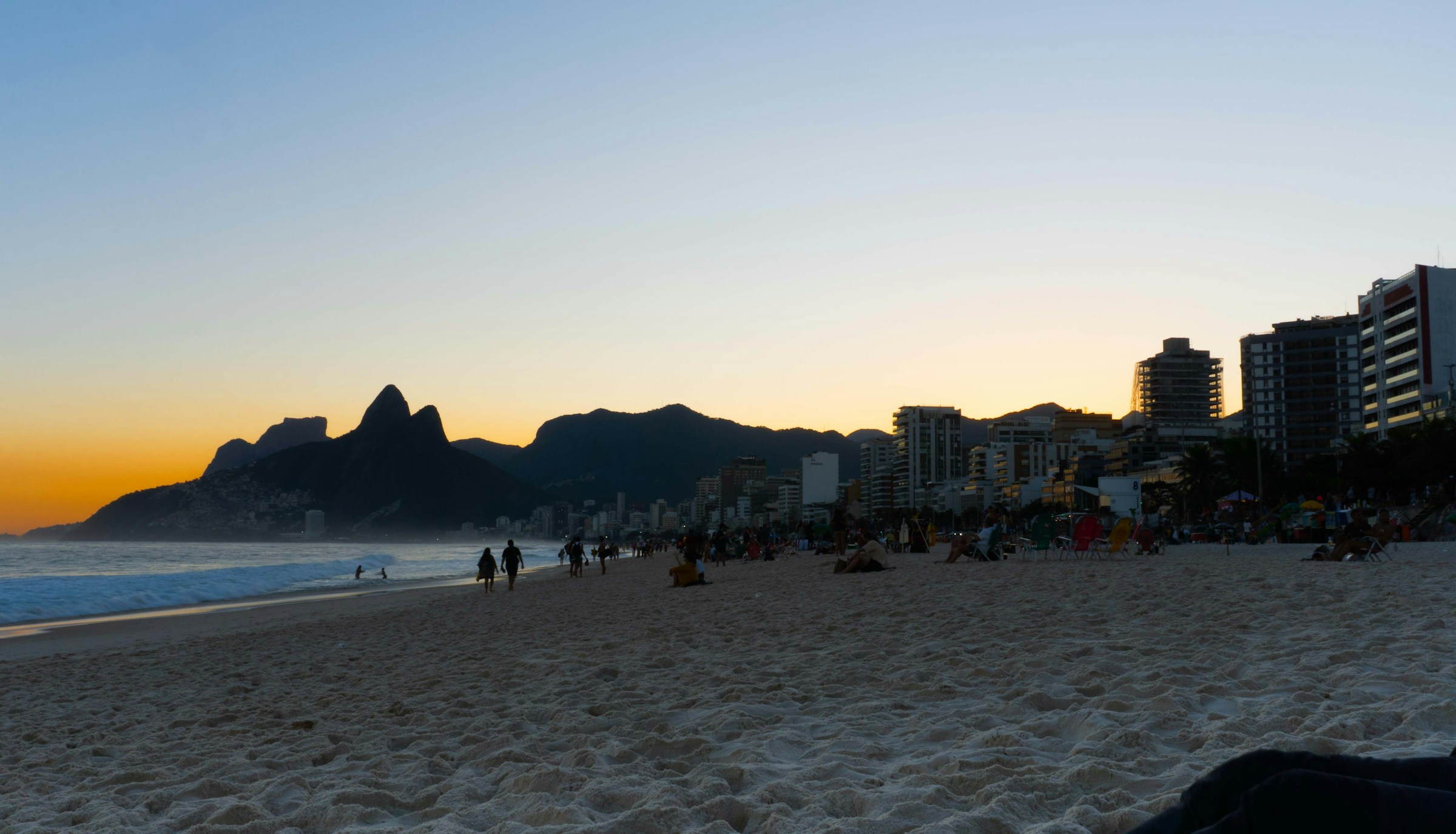 Beach at sunset with mountains and city buildings, Da Nang