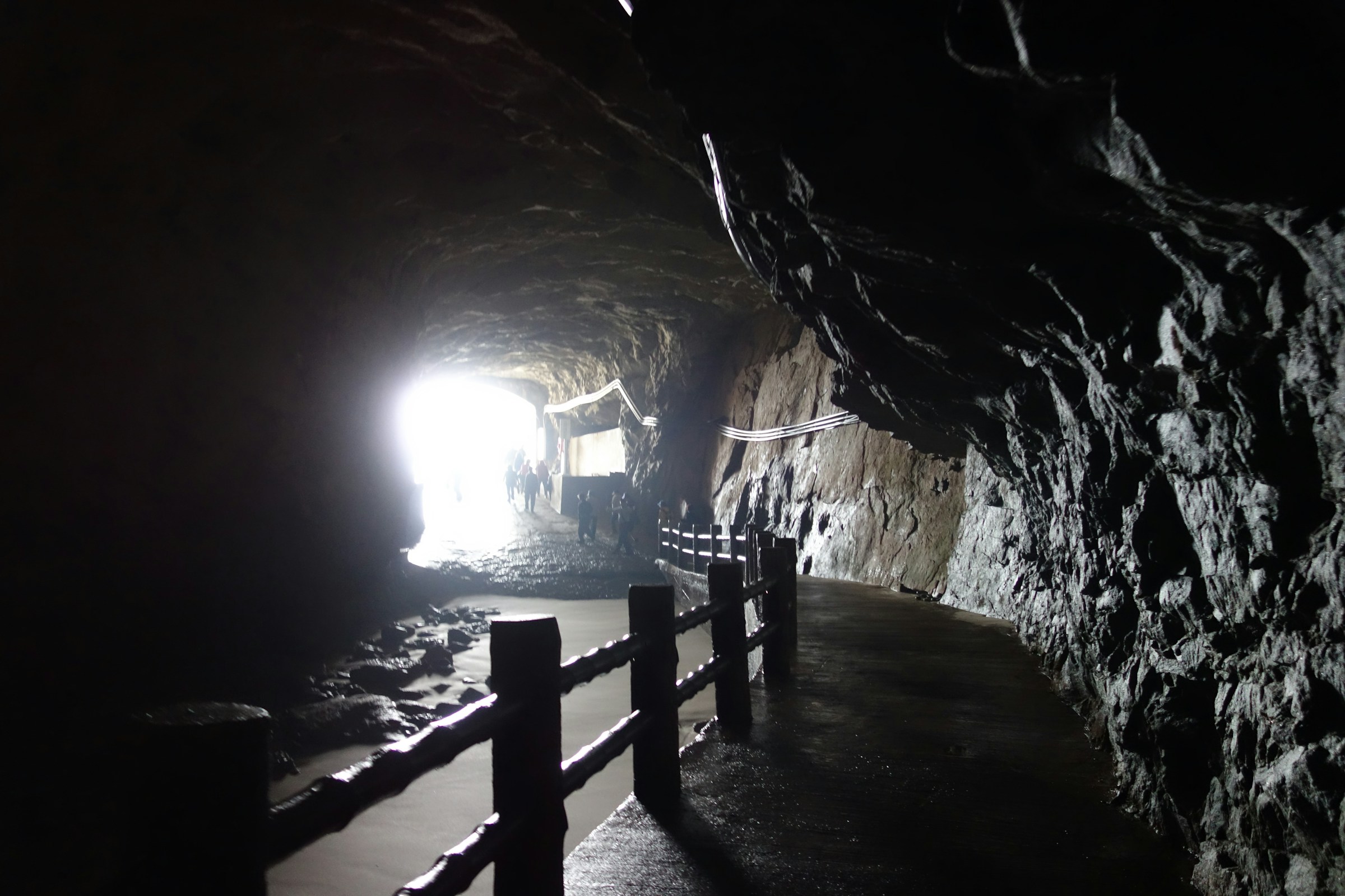 Dark cave tunnel with a light at the end, Cu Chi Tunnels