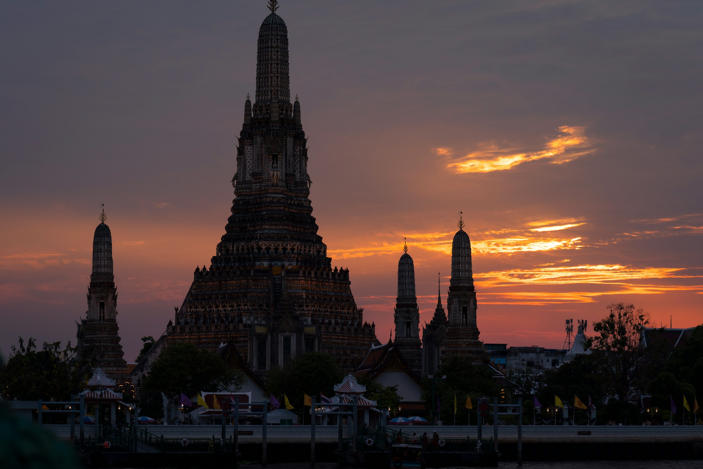 Wat Arun temple towers against a dramatic sunset