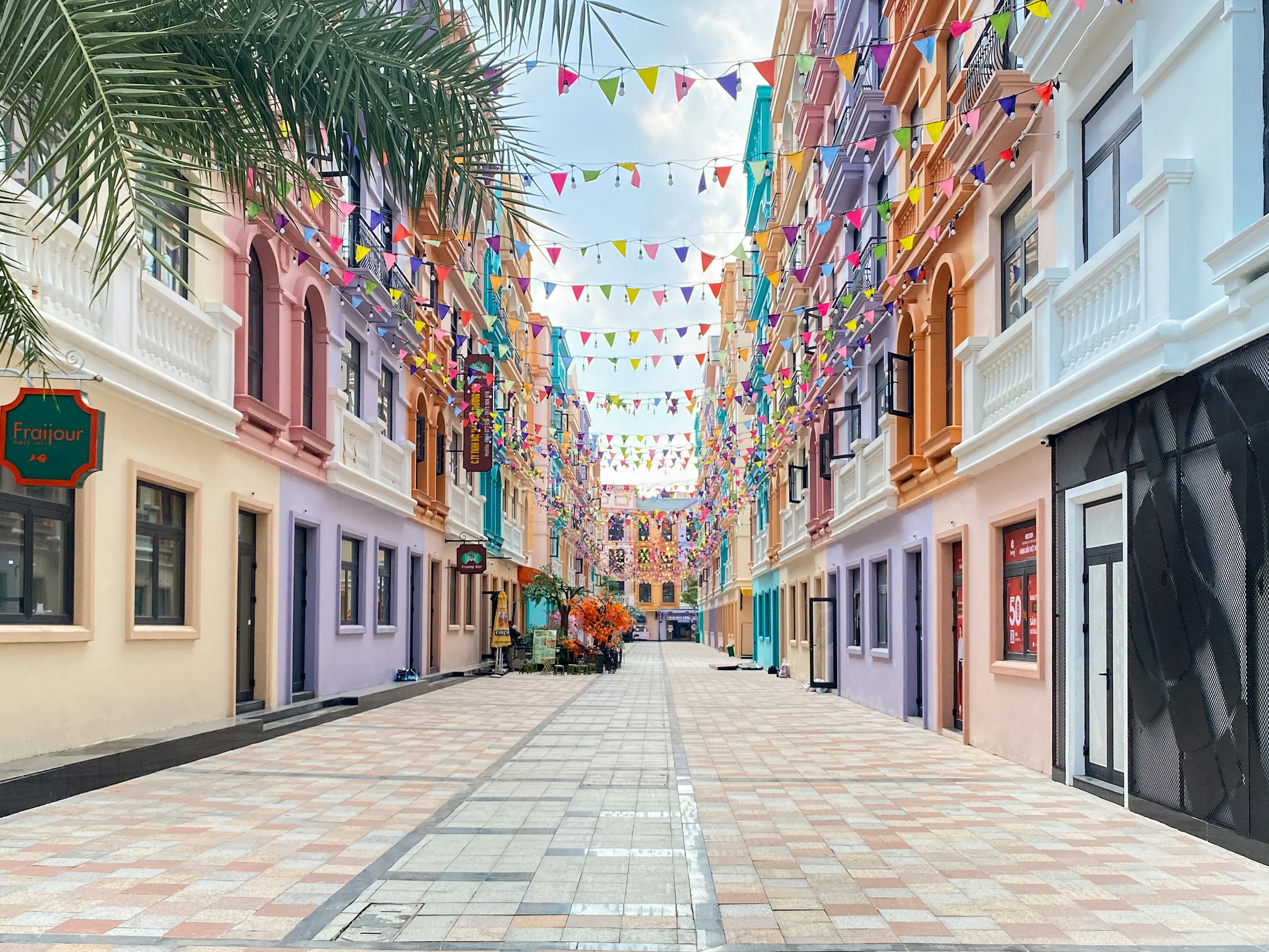 Colourful street lined with buildings and palm trees