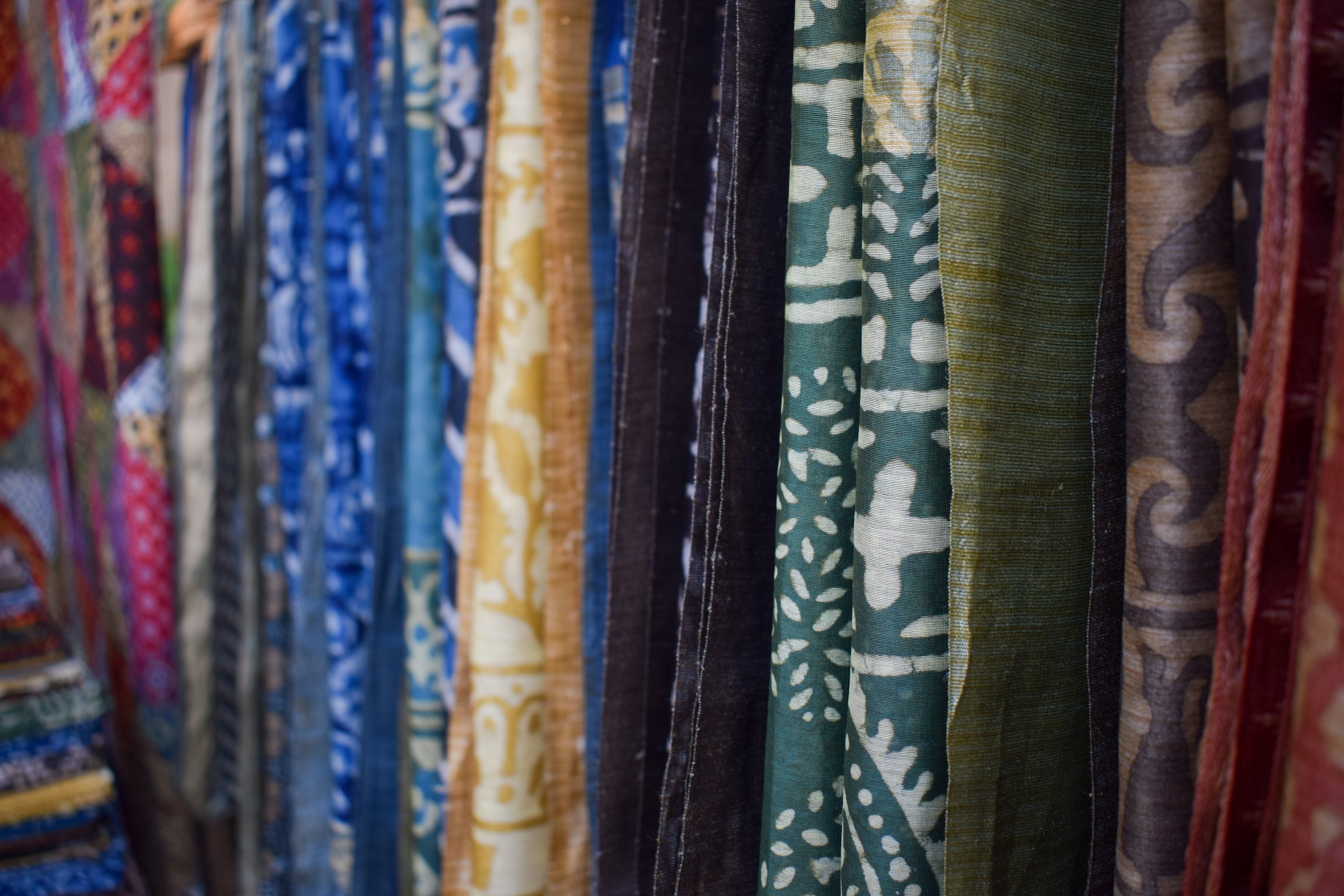 Colourful patterned fabrics hanging in a row, Jaipur bazaar