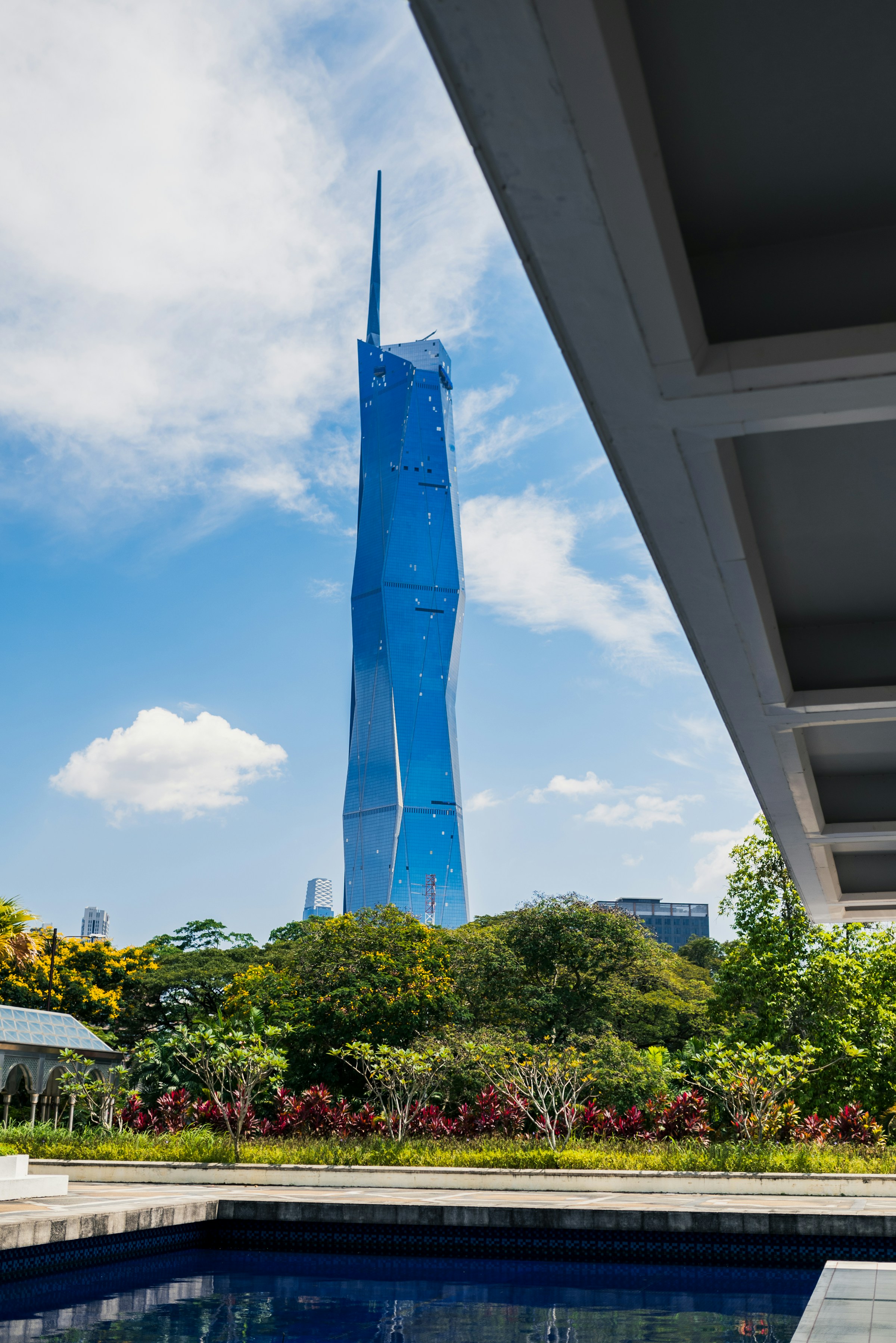 Modern skyscraper towers over pool and greenery