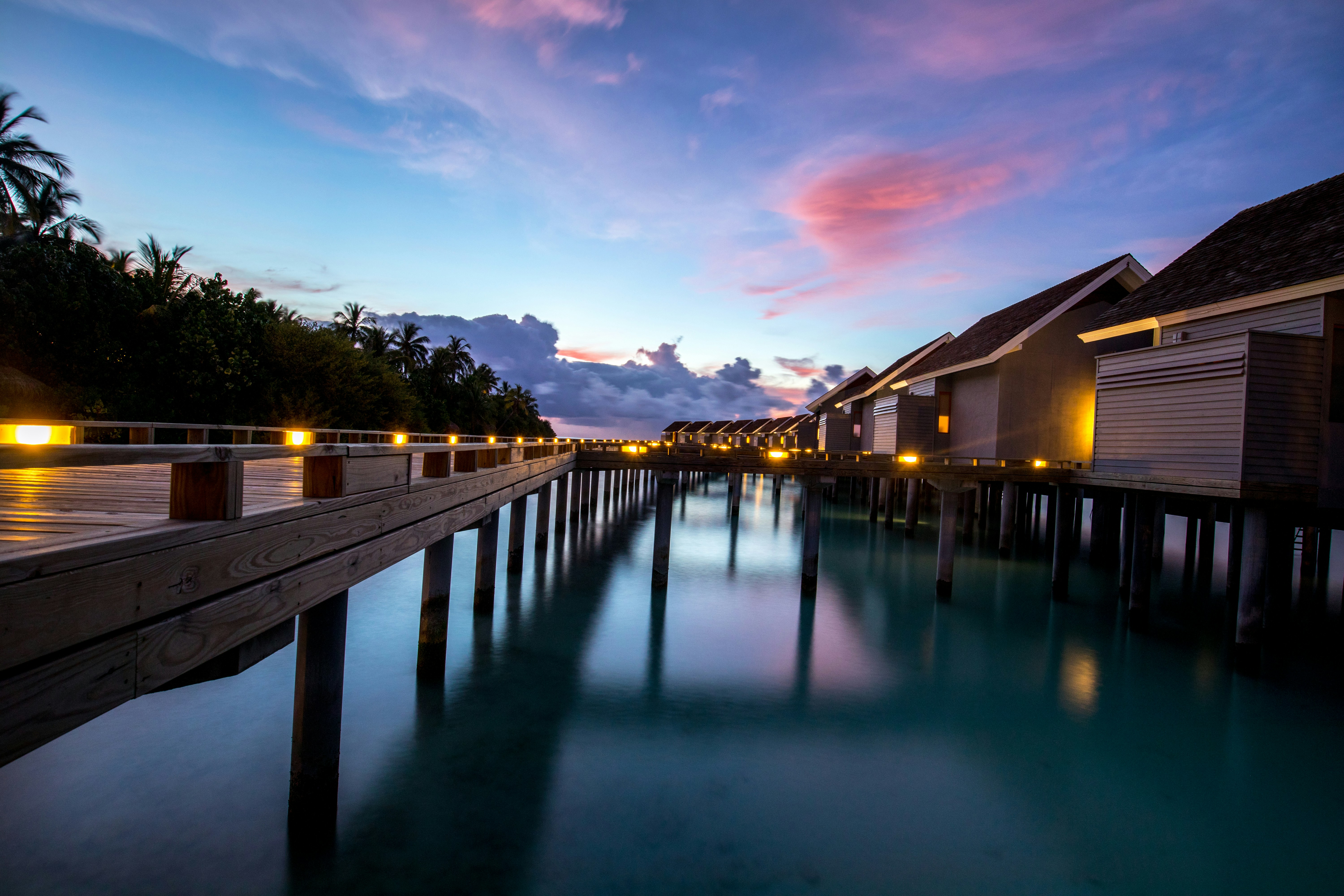 Illuminated overwater bungalows at twilight