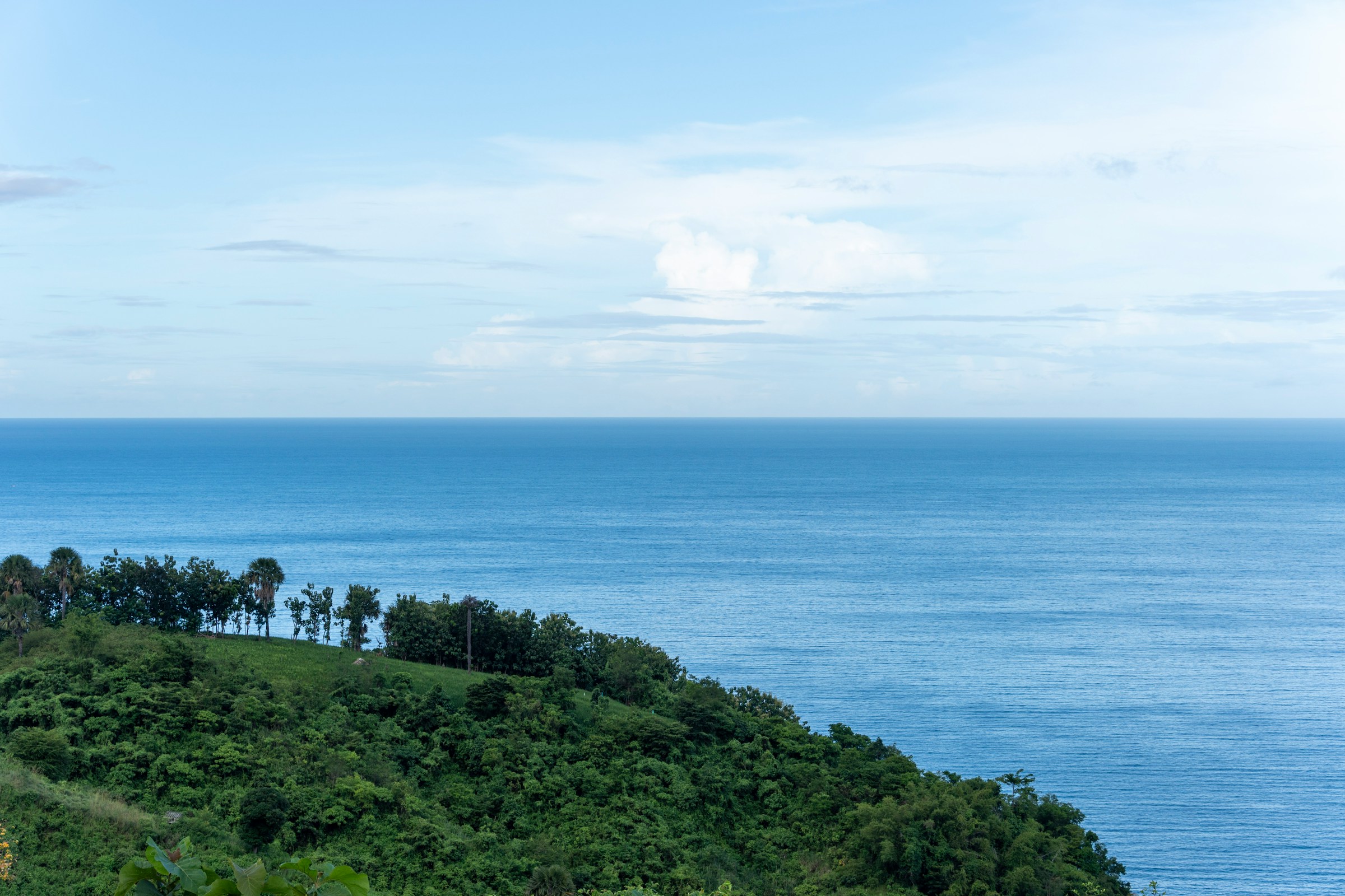 Green hillside overlooking the vast blue ocean