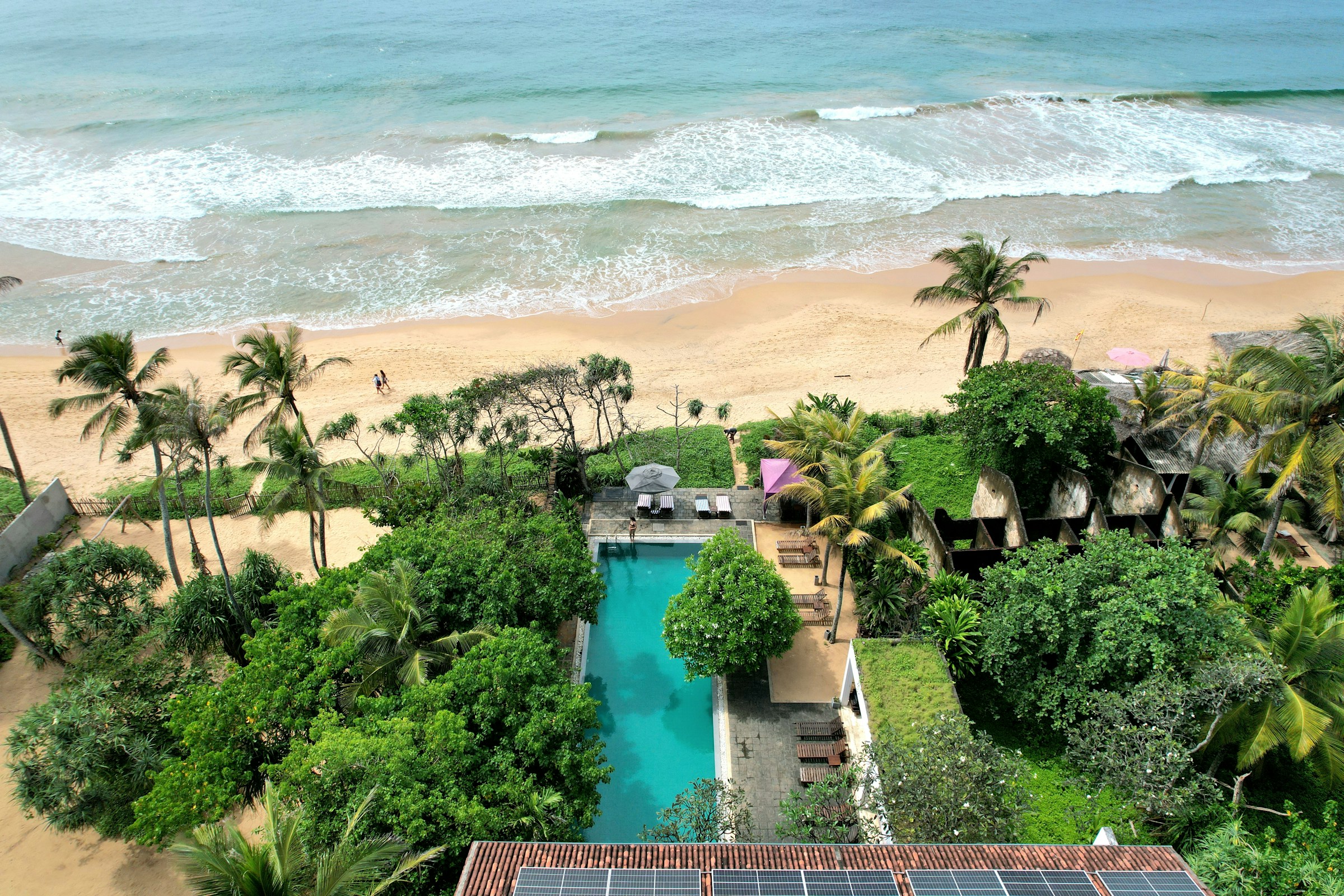 Tropical resort pool overlooking ocean and beach