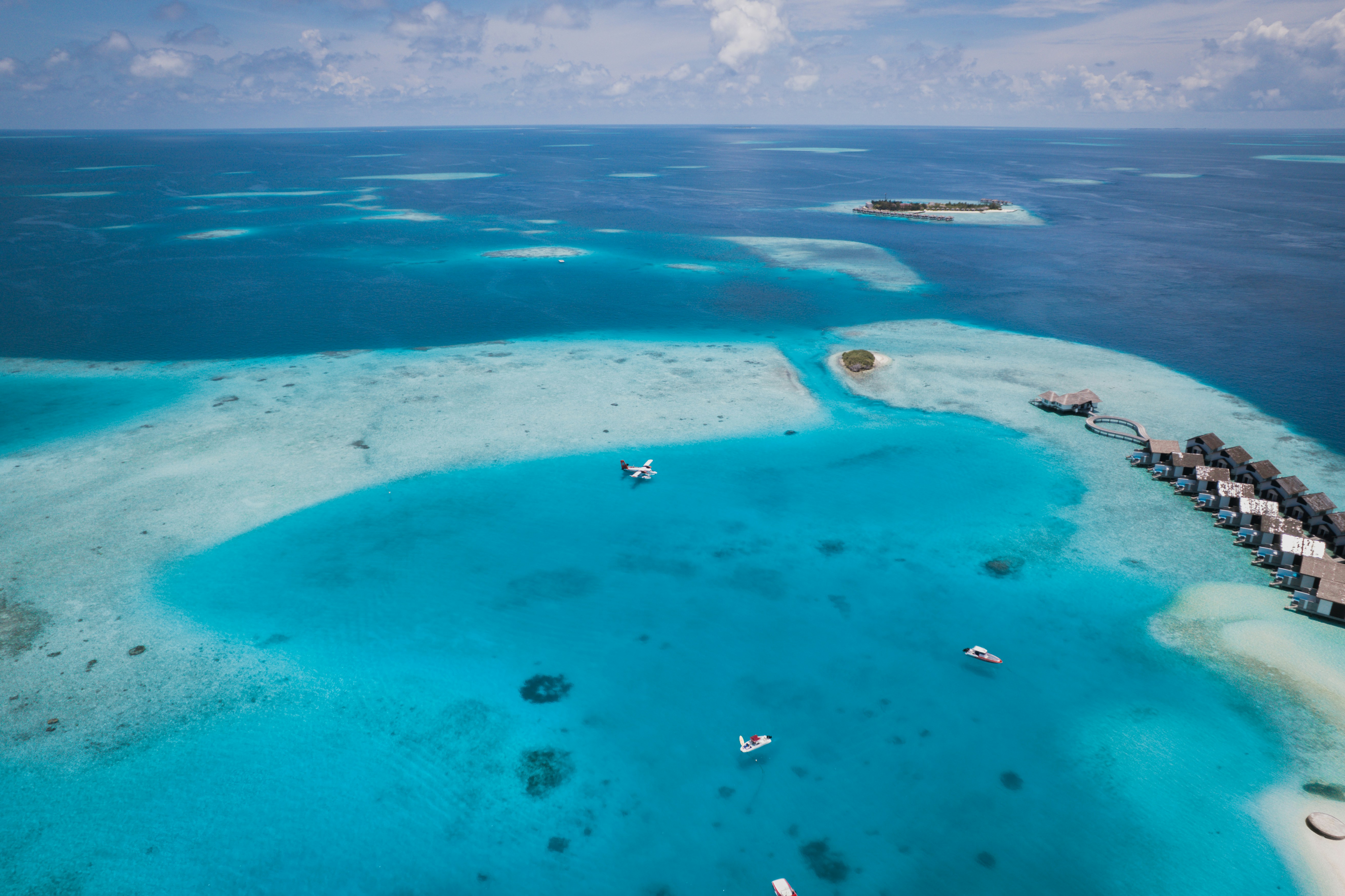 Aerial view of overwater bungalows and coral reef