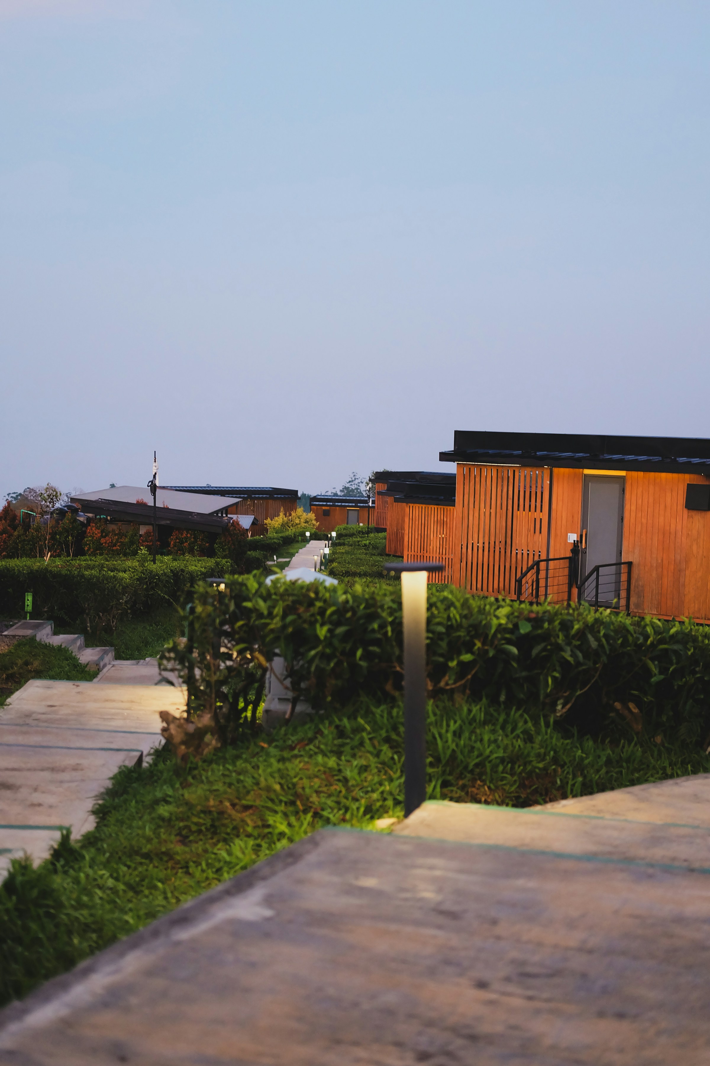 Modern cabins with a pathway and garden at dusk