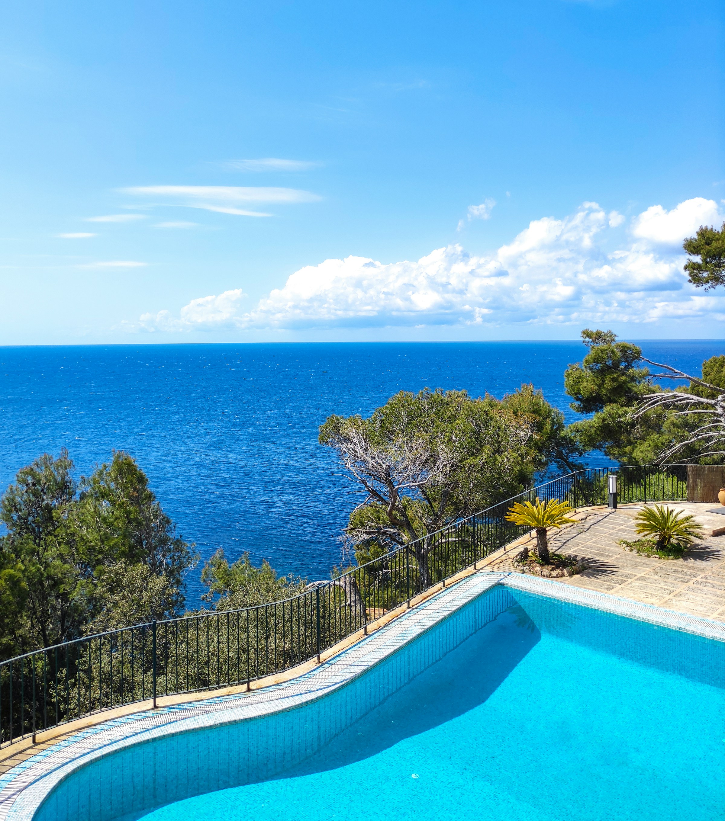 Bright blue swimming pool overlooking the ocean
